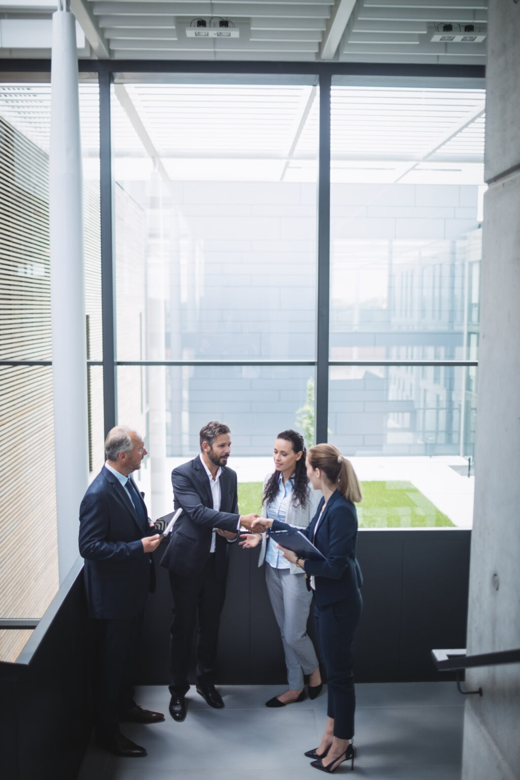 group of businesspeople having a discussion near staircase in office